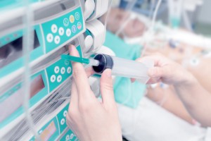 Syringe in the hand of a nurse on the background of the patient