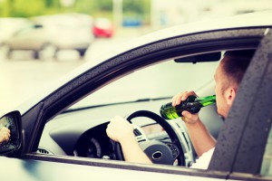 man drinking alcohol while driving the car